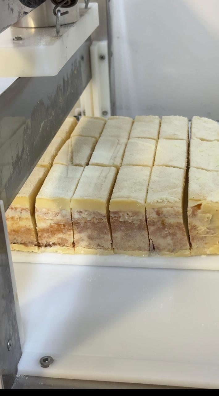 bolo gelado sendo fatiado congelado antes da embalagem individual