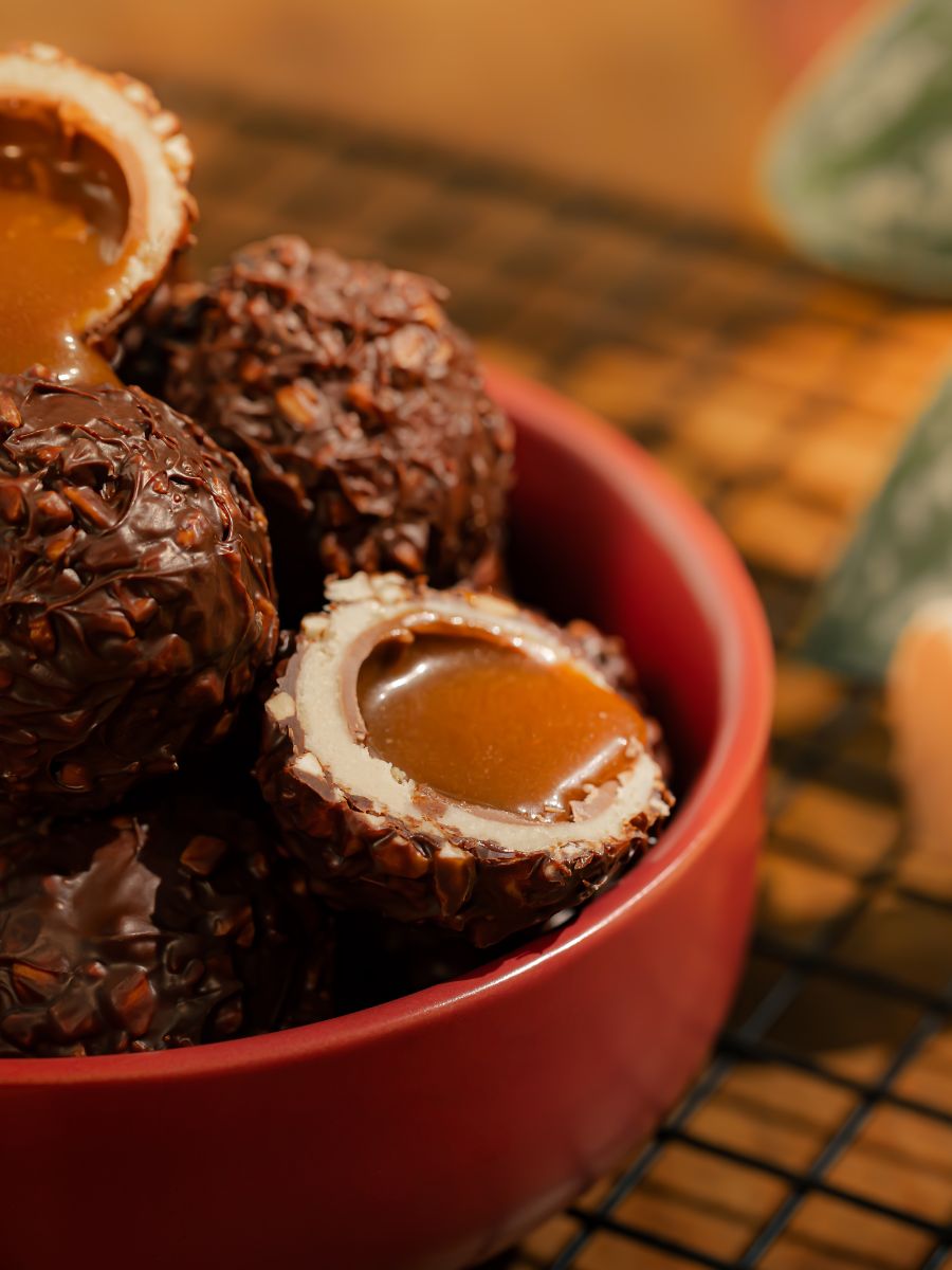 Bombons de chocolate crocante com recheio de caramelo numa tigela vermelha