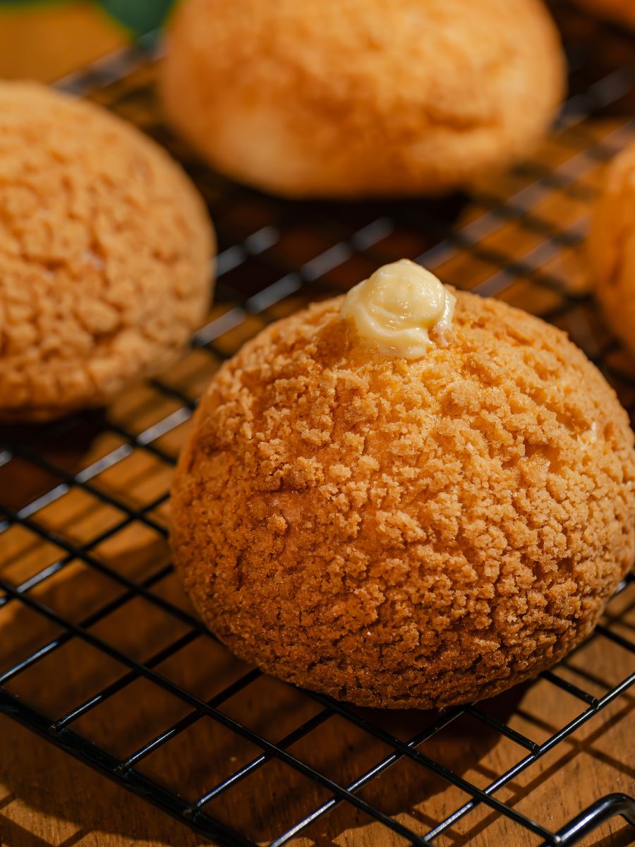 Choux cream dourado com farofa crocante e recheio de creme no topo