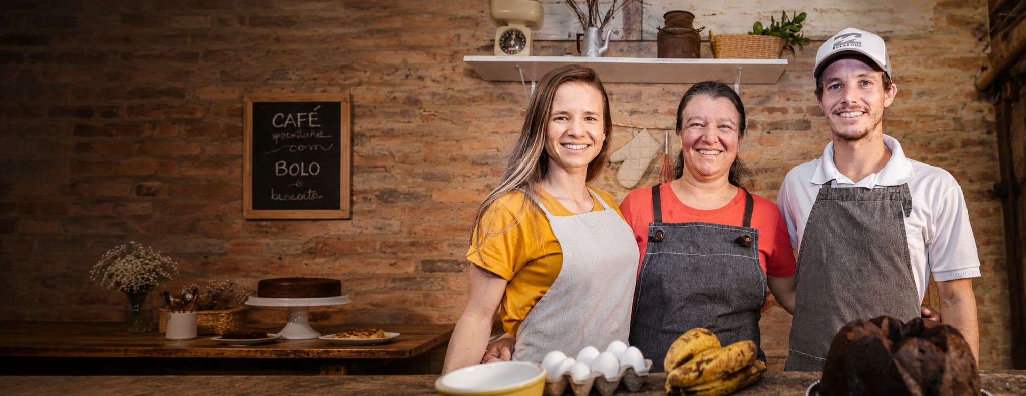 Equipe da família Mombee sorrindo atrás do balcão da loja